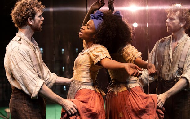 Actors performing a scene from "Slave Play" on stage.