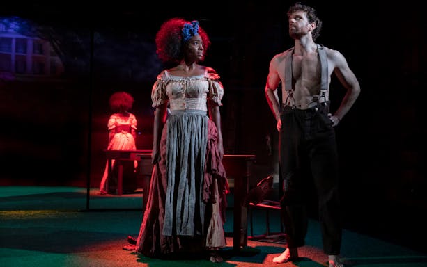 Actors performing a scene from "Slave Play" on stage.