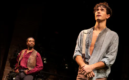 Actors performing a scene from "Slave Play" on stage.