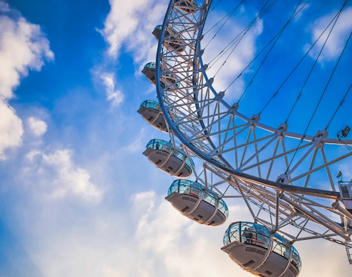 London Eye capsules against a blue sky, part of the river cruise experience.