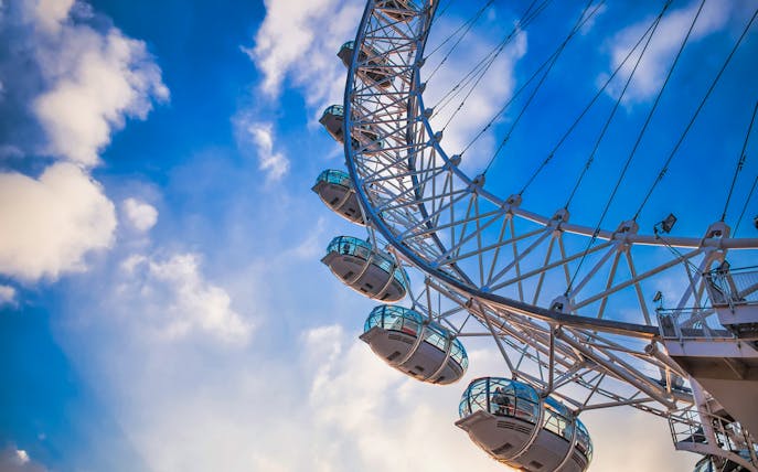 London Eye capsules against a blue sky, part of the river cruise experience.