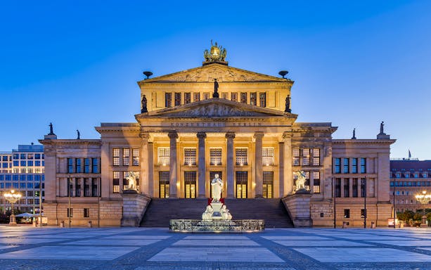 Konzerthaus Berlin illuminated at dusk, featured on Red Bus Berlin Tour.