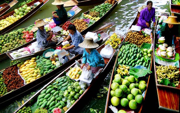 Boats filled with fruits and vendors at Damnern Saduak Floating Market, Thailand.