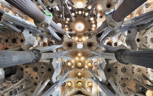 Sagrada Familia interior ceiling with intricate columns and stained glass, Barcelona.
