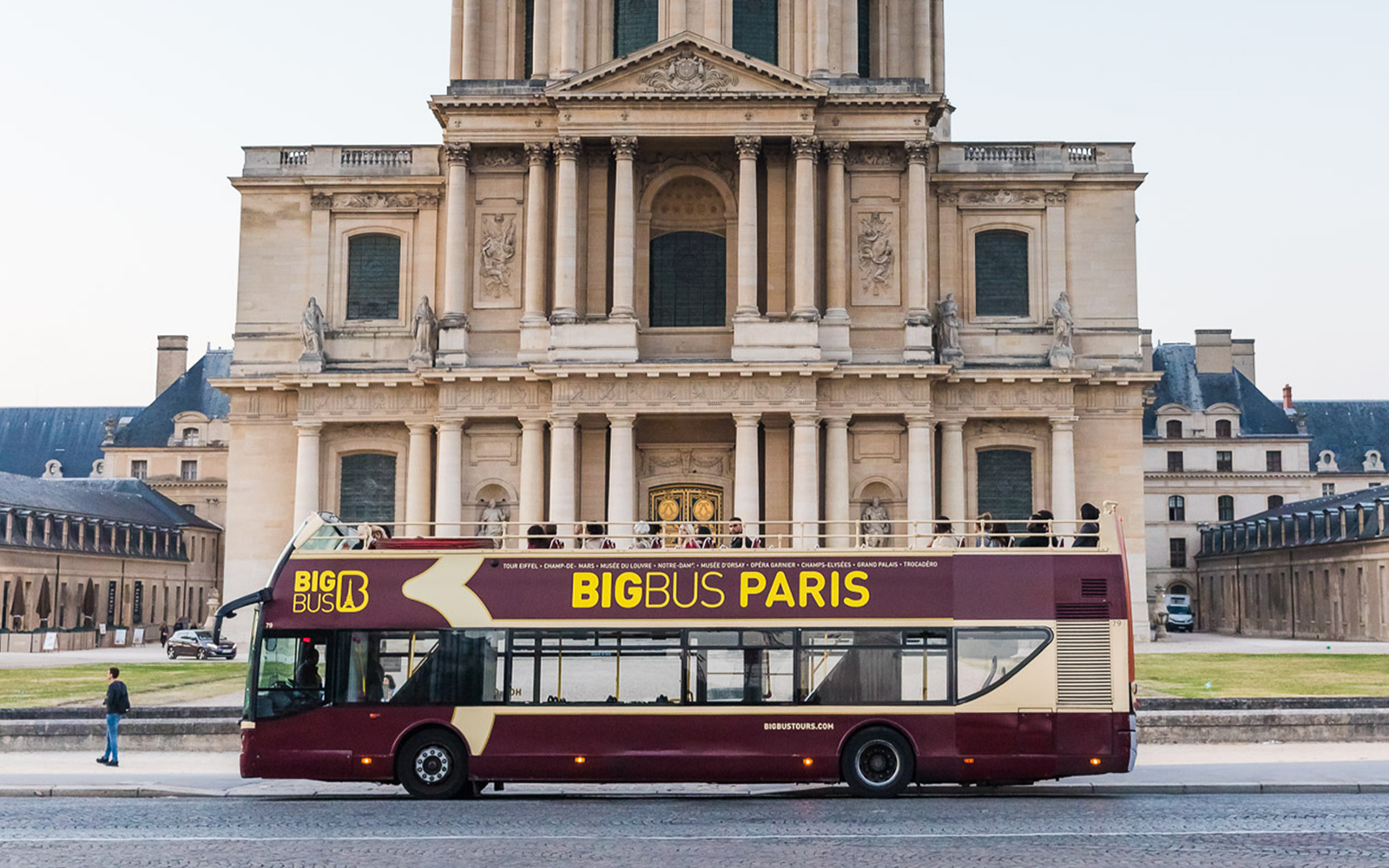 Big Bus Paris tour in front of historic building, part of Opera Garnier Skip the Line experience.