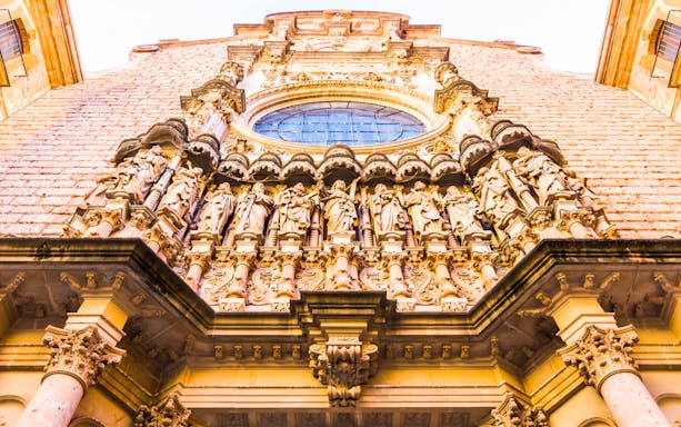 Montserrat Monastery facade with detailed sculptures, Spain.