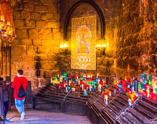 Montserrat Monastery with tourists on a guided tour, surrounded by mountain views, Barcelona, Spain.