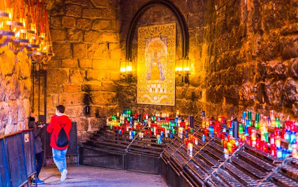 Candles and mosaic inside Montserrat Monastery during guided tour, Spain.