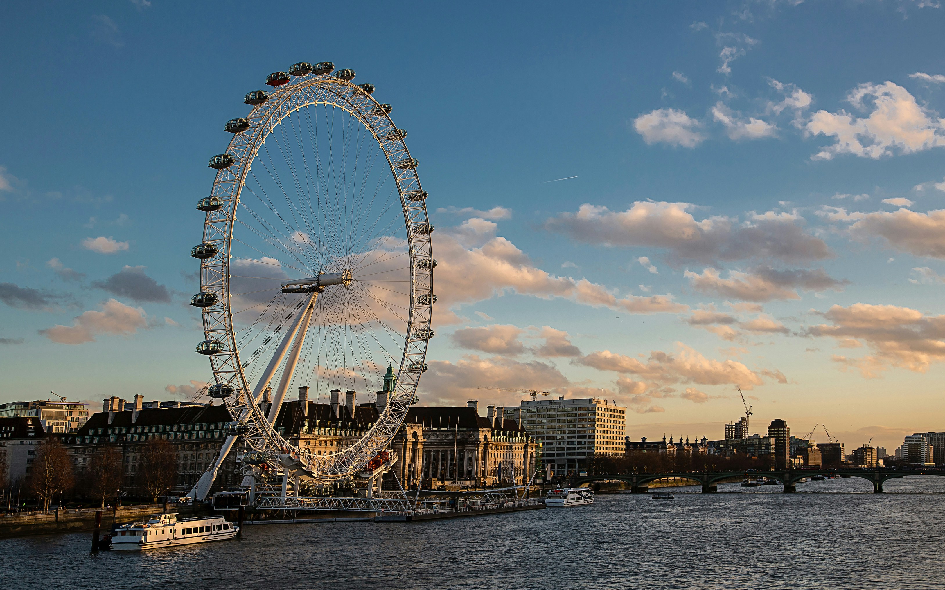 London Eye and Thames River with boats near Westminster.