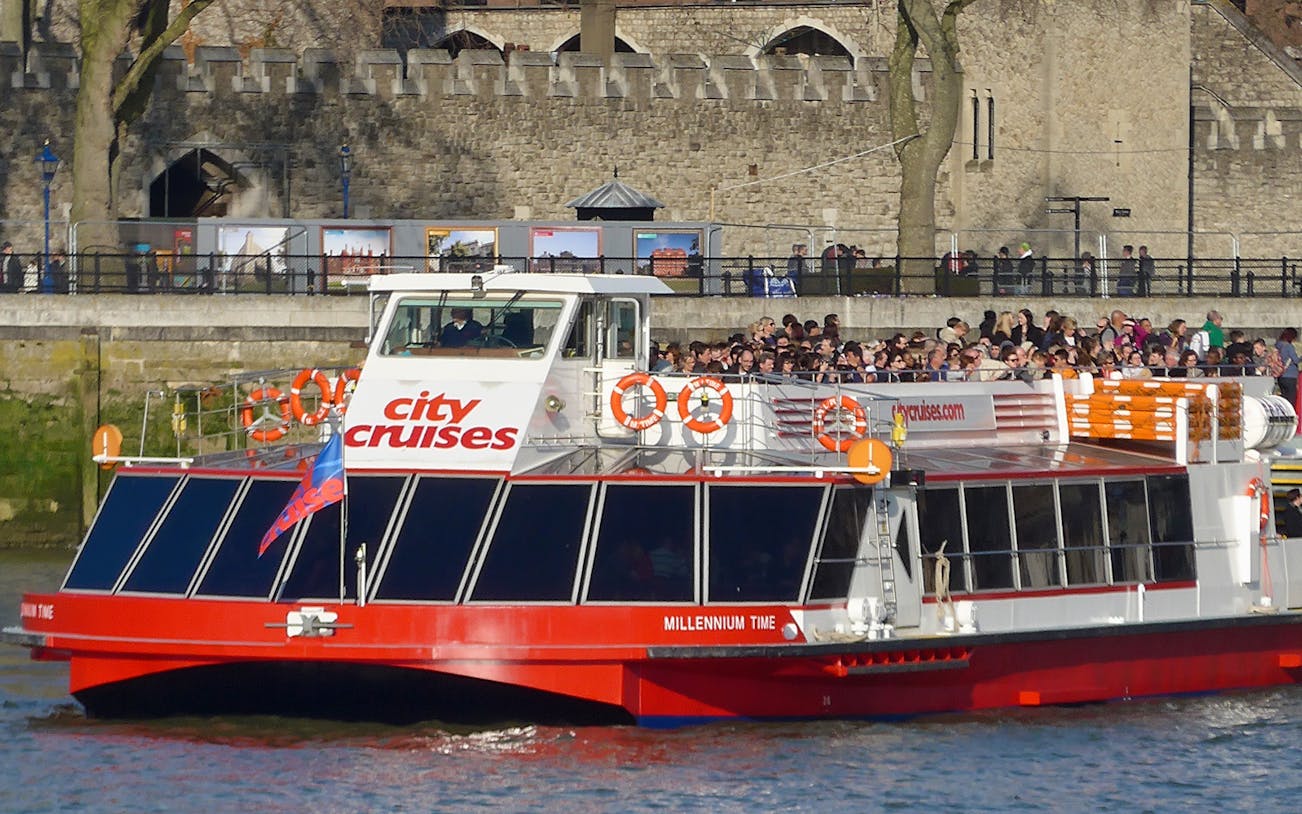 City Cruises boat on the Thames near Tower of London, offering return tickets to Westminster/London Eye.