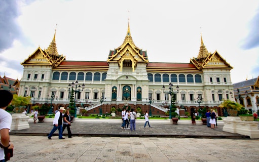 Grand Palace in Bangkok with tourists exploring the grounds.