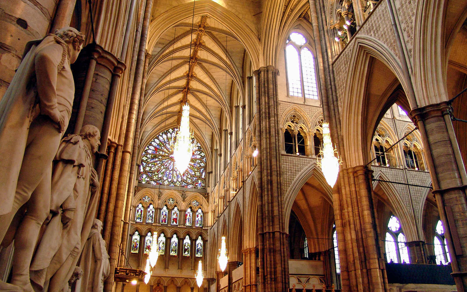 Westminster Abbey interior with statues and stained glass windows, London.
