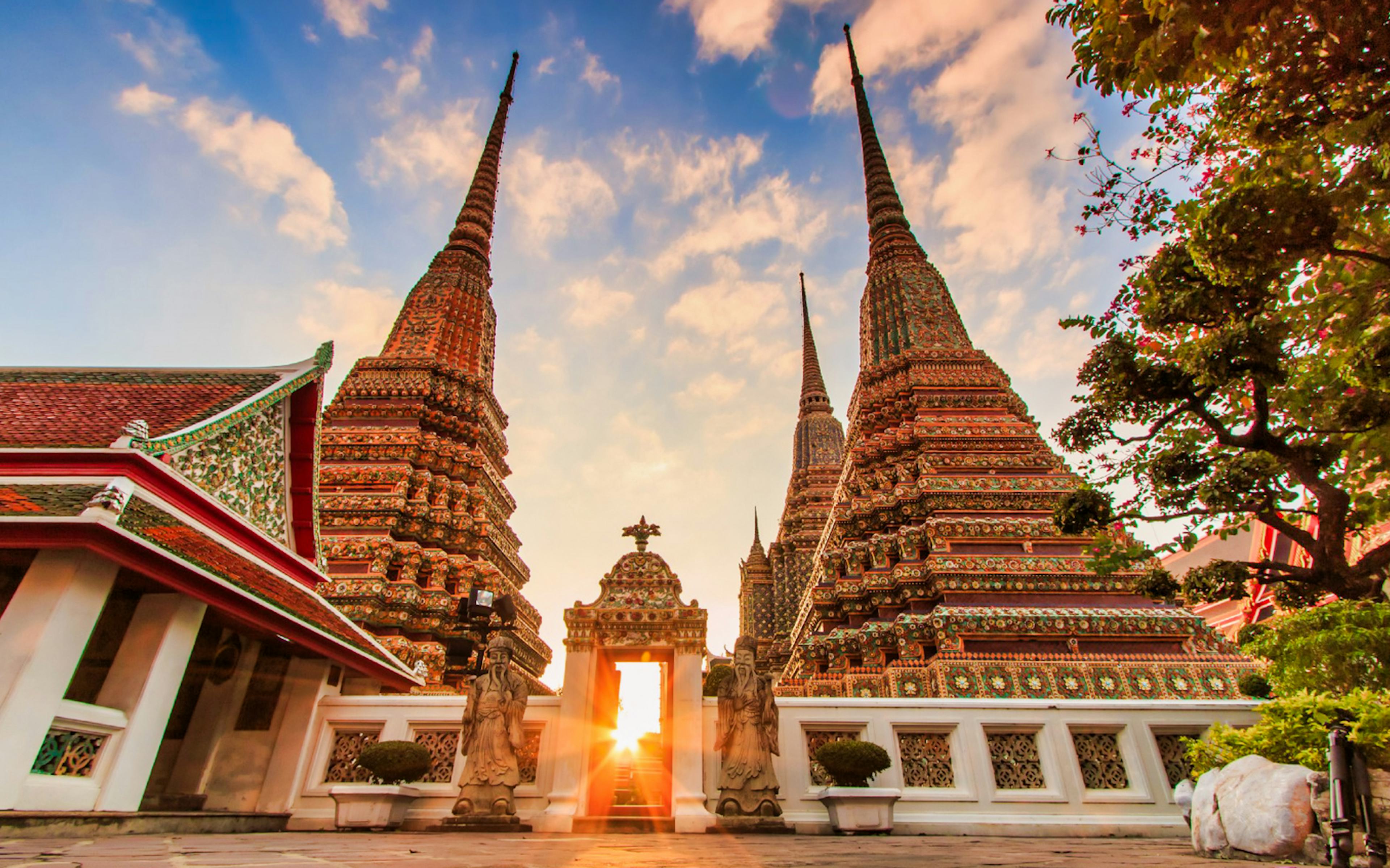 Wat Arun temple spires at sunset in Bangkok, part of Klong and Flower Market tour.