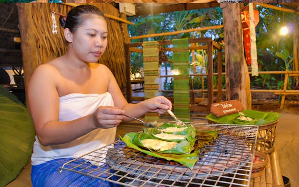 Woman preparing traditional Thai omelette at Siam Niramit Bangkok show.
