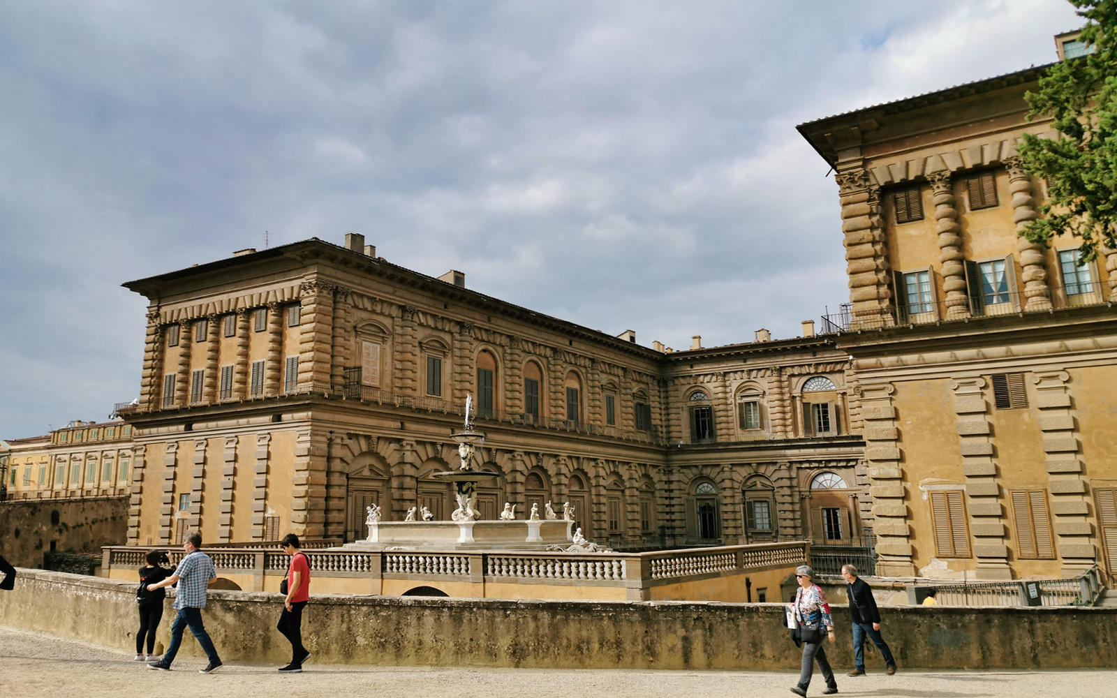 Palazzo Pitti exterior with visitors walking, Florence, Italy.