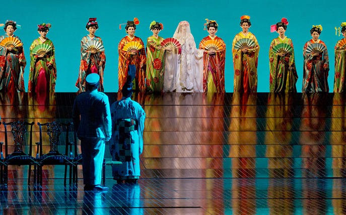 Performers in traditional attire on stage during Madama Butterfly opera.