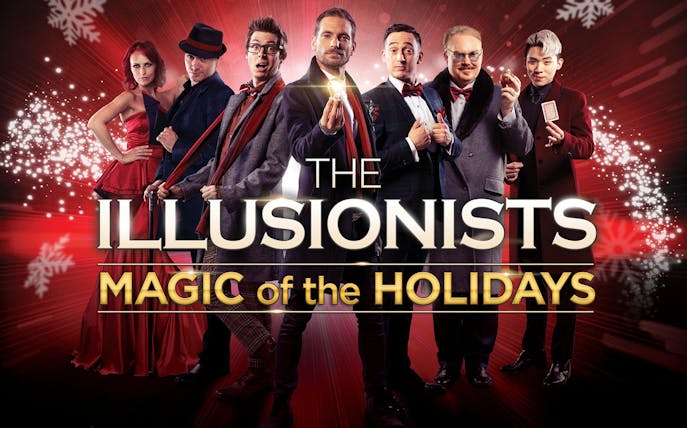 Illusionists performing holiday magic show with festive background.