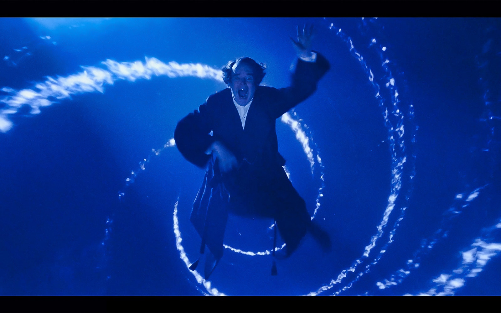 Man in dark coat falling through swirling blue vortex, scene from A Christmas Carol.