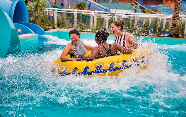 People enjoying a water ride at a Dubai water park, part of the All-Inclusive 7 Day Dubai Package.