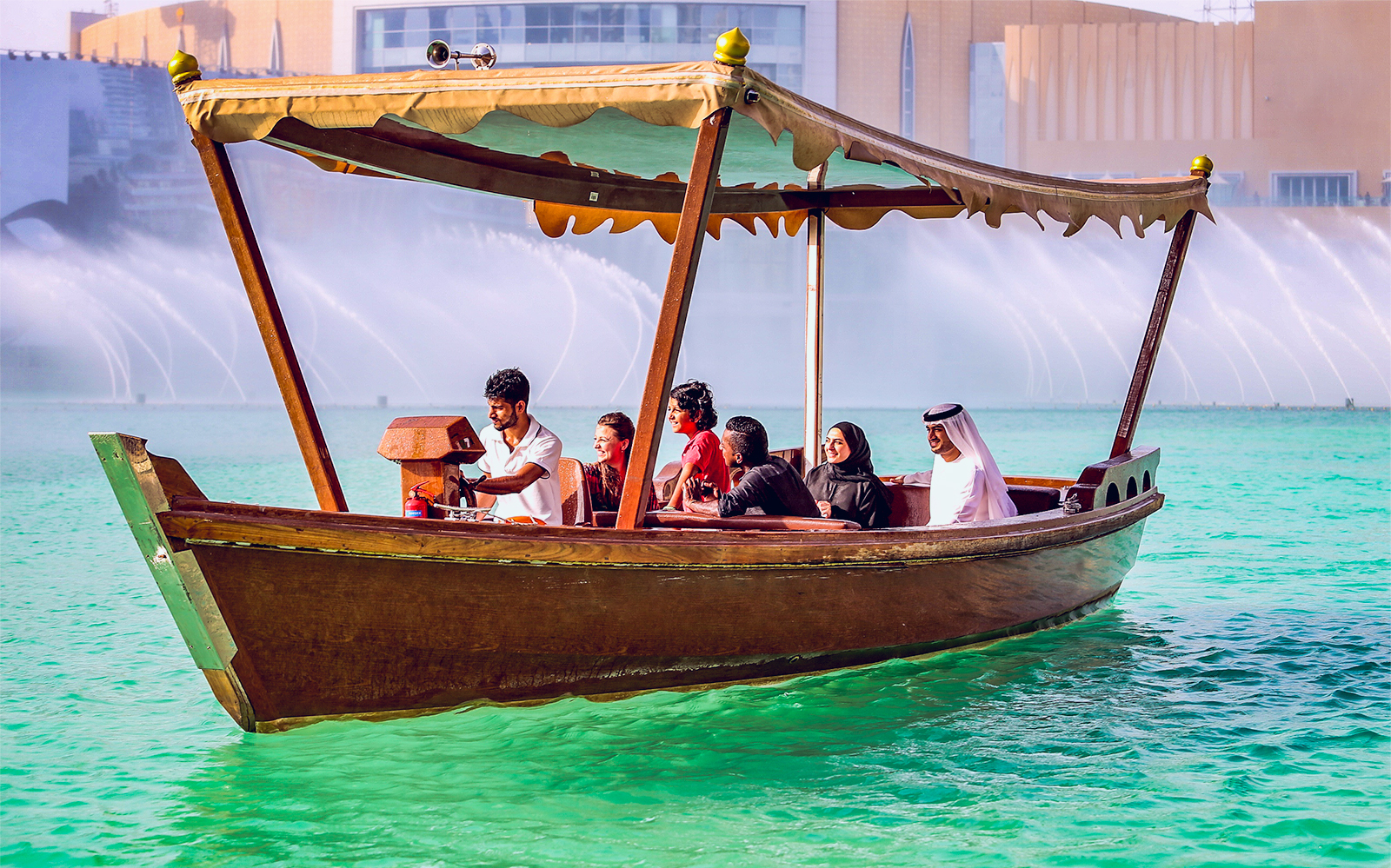 Boat tour on Dubai Fountain lake with cityscape backdrop.