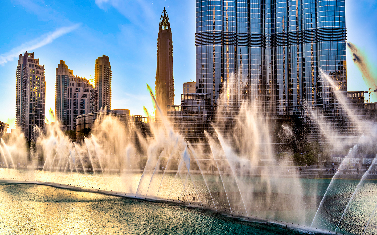 Dubai Fountain show with Burj Khalifa in the background during sunset.