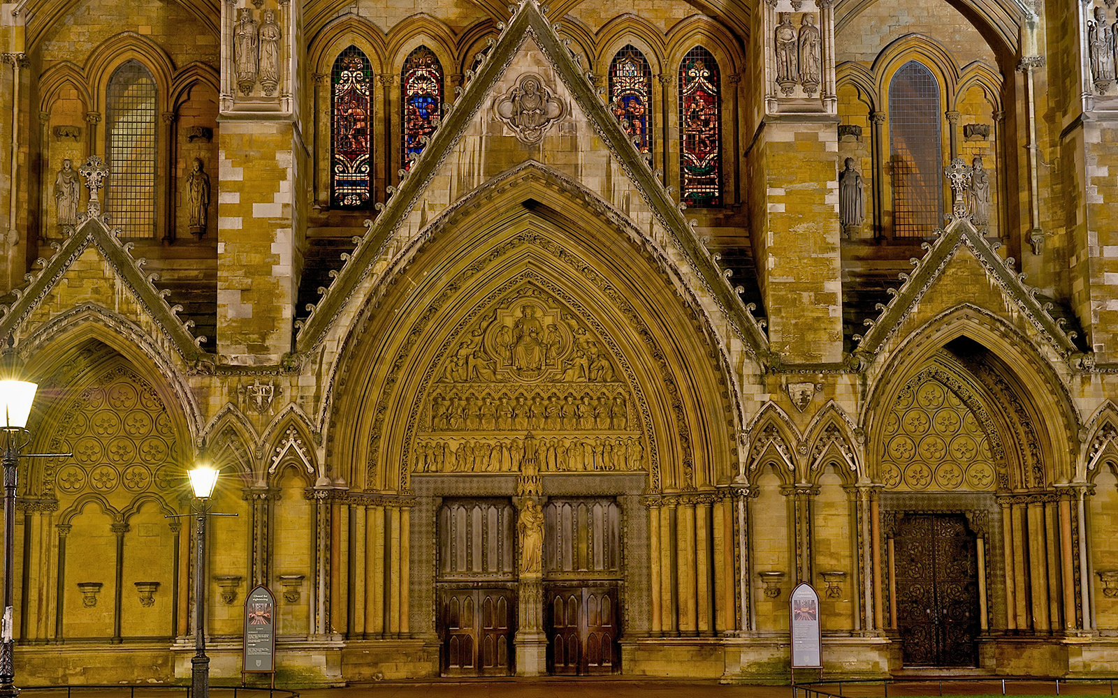 Westminster Abbey entrance with ornate arches and stained glass windows, London.