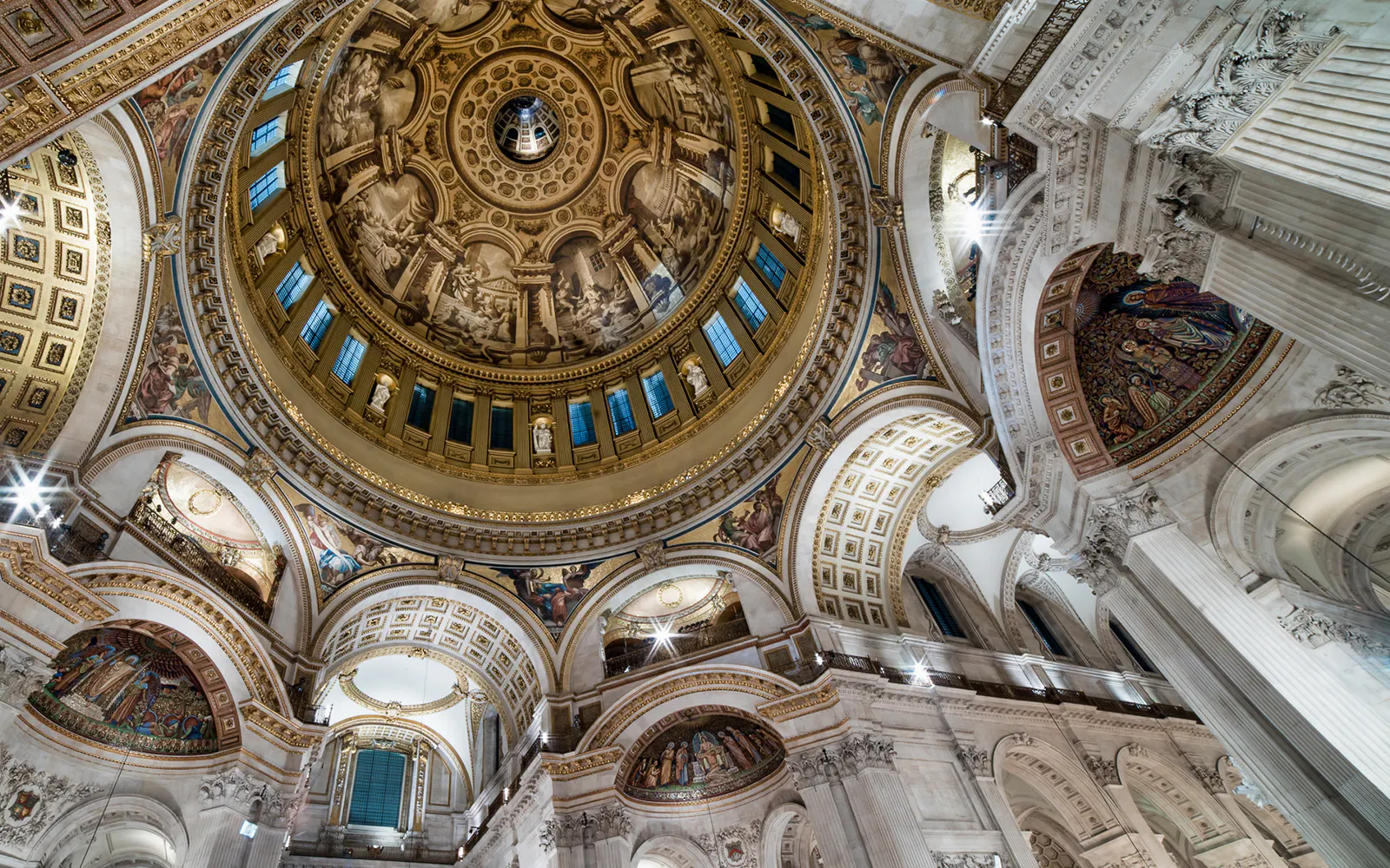 Interior view of St Paul's Cathedral dome in London, showcasing intricate architecture and artwork.