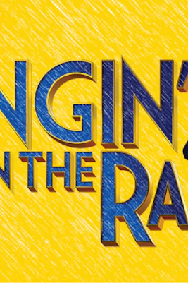 Performers dancing with umbrellas on stage during Singin' In The Rain musical.