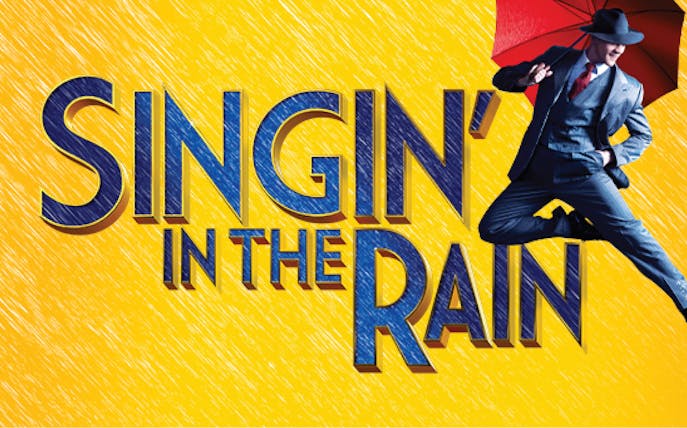 Performers dancing with umbrellas on stage during Singin' In The Rain musical.