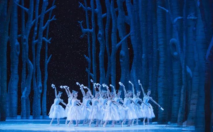Ballet dancers performing in a snowy forest scene from George Balanchine's The Nutcracker.
