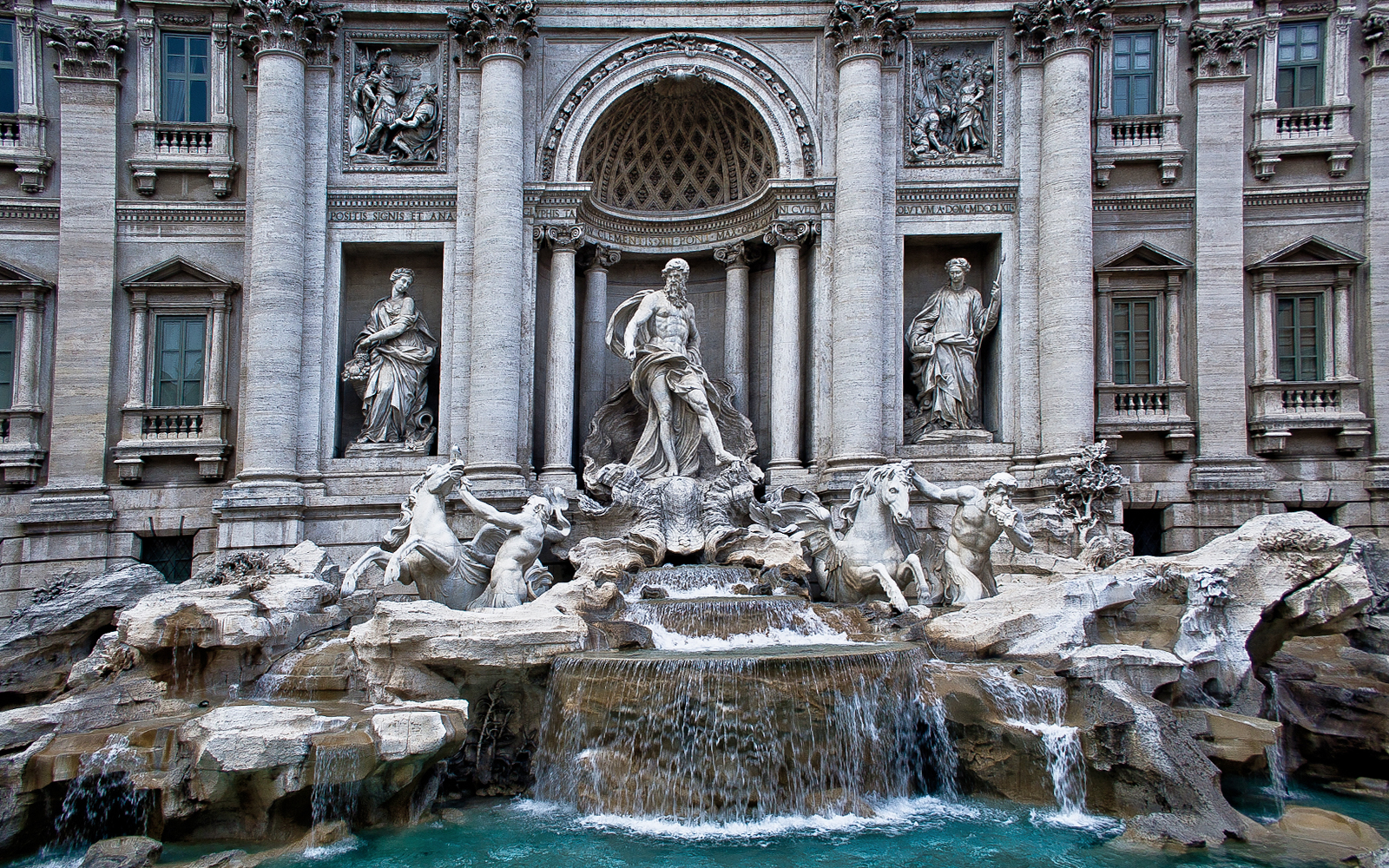 Trevi Fountain in Rome with ornate sculptures and cascading water.