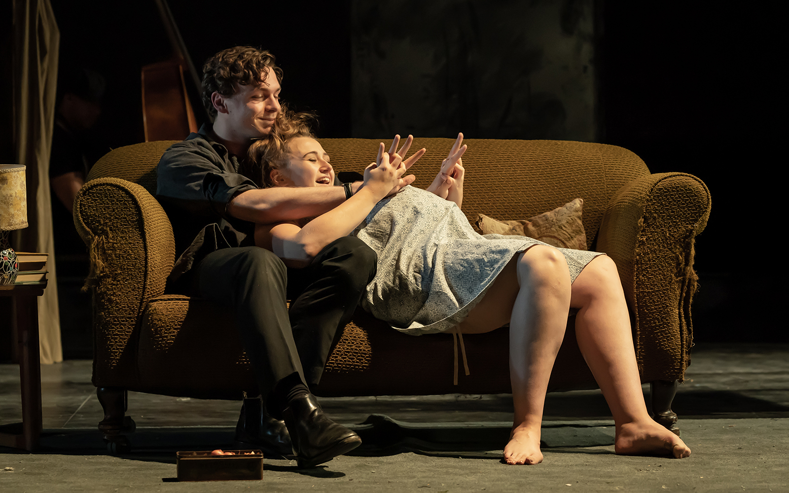 Couple sitting on a sofa during a theater performance of "A Taste of Honey.