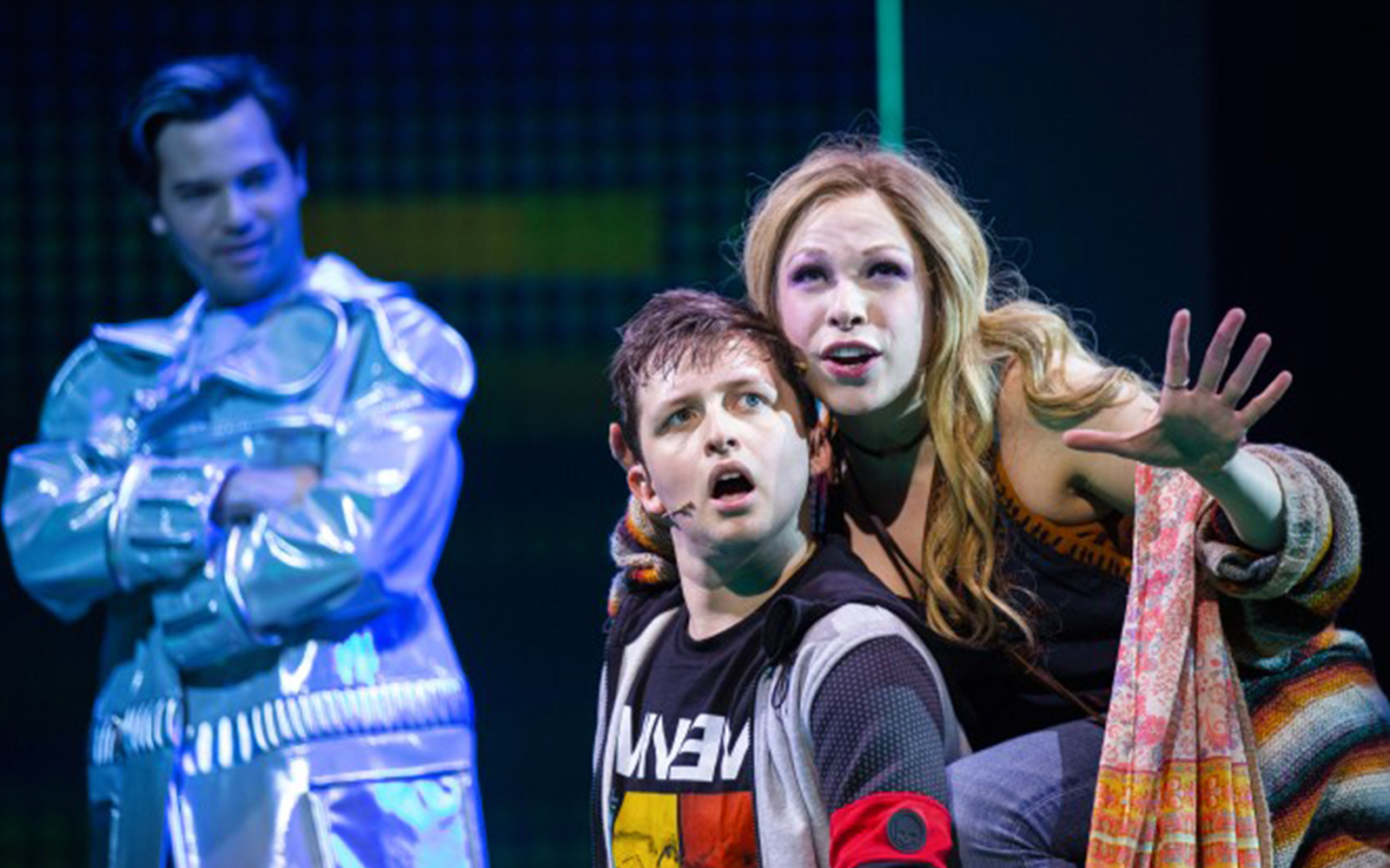 Actors performing a scene from "Be More Chill" musical on stage.