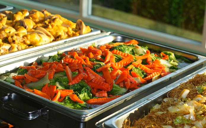 Buffet with stir-fried vegetables, chicken, and noodles at Nong Nooch Tropical Garden.