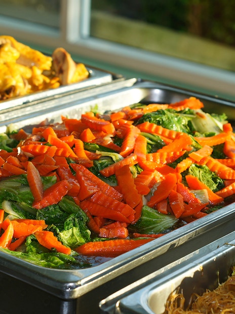 Buffet with stir-fried vegetables, chicken, and noodles at Nong Nooch Tropical Garden.