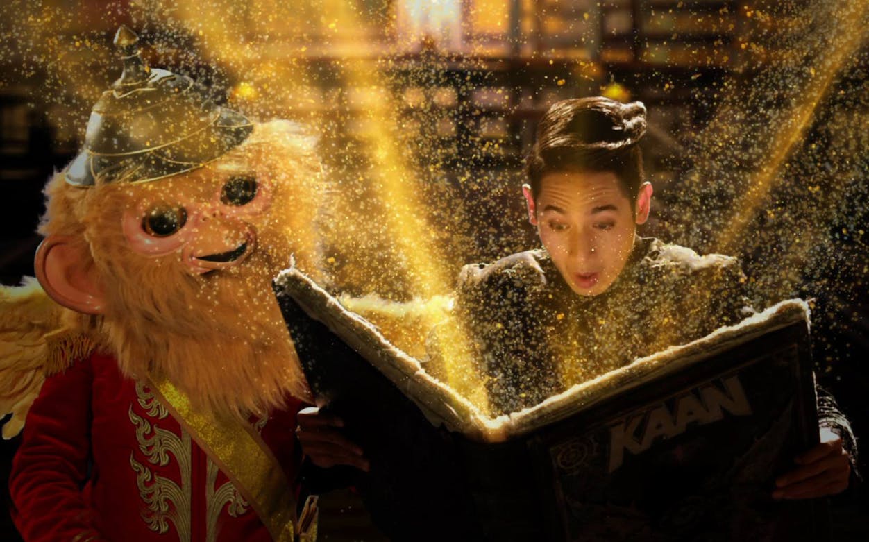 Man and costumed character reading magical book at KAAN Show.