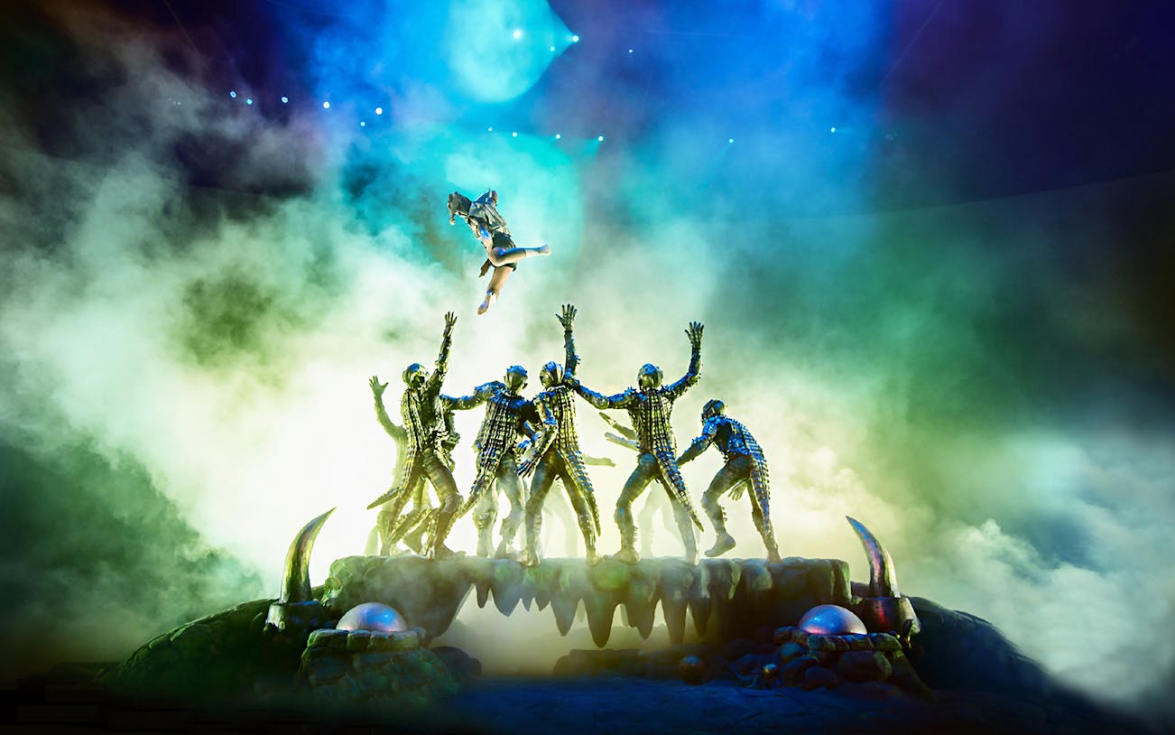 Performers in elaborate costumes during a KAAN Show act with dramatic lighting.