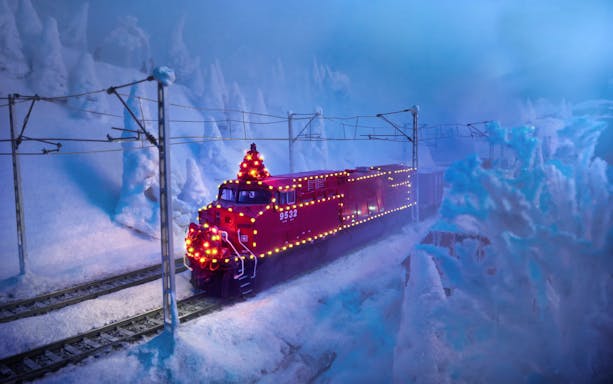 Model train with festive lights in snowy Miniatur Wunderland display.