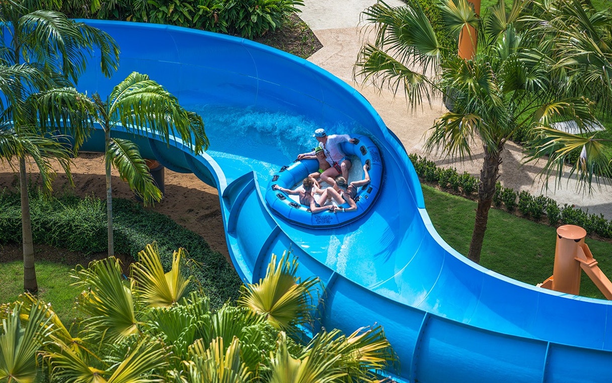 Group enjoying a raft ride on a blue water slide at Splash Jungle Waterpark.