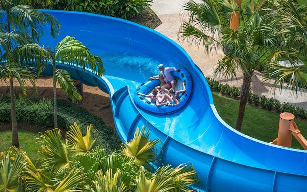 Group enjoying a raft ride on a blue water slide at Splash Jungle Waterpark.
