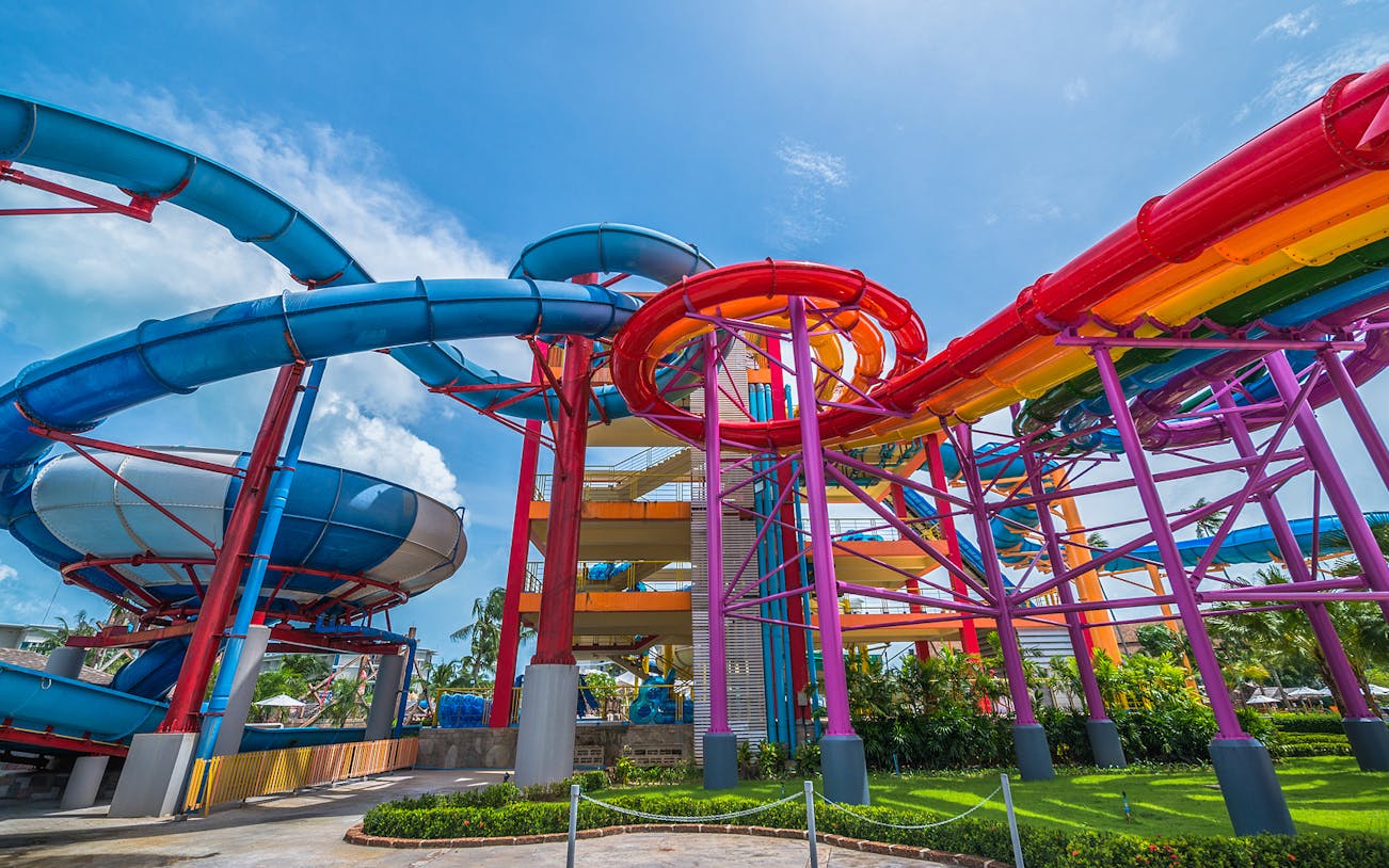 Colorful water slides at Splash Jungle Waterpark, featuring vibrant tubes and lush surroundings.