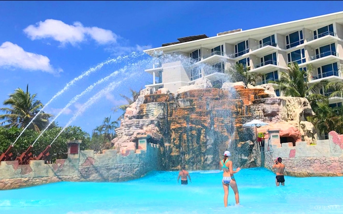 Visitors enjoying the wave pool at Splash Jungle Waterpark with water jets and rock formations.