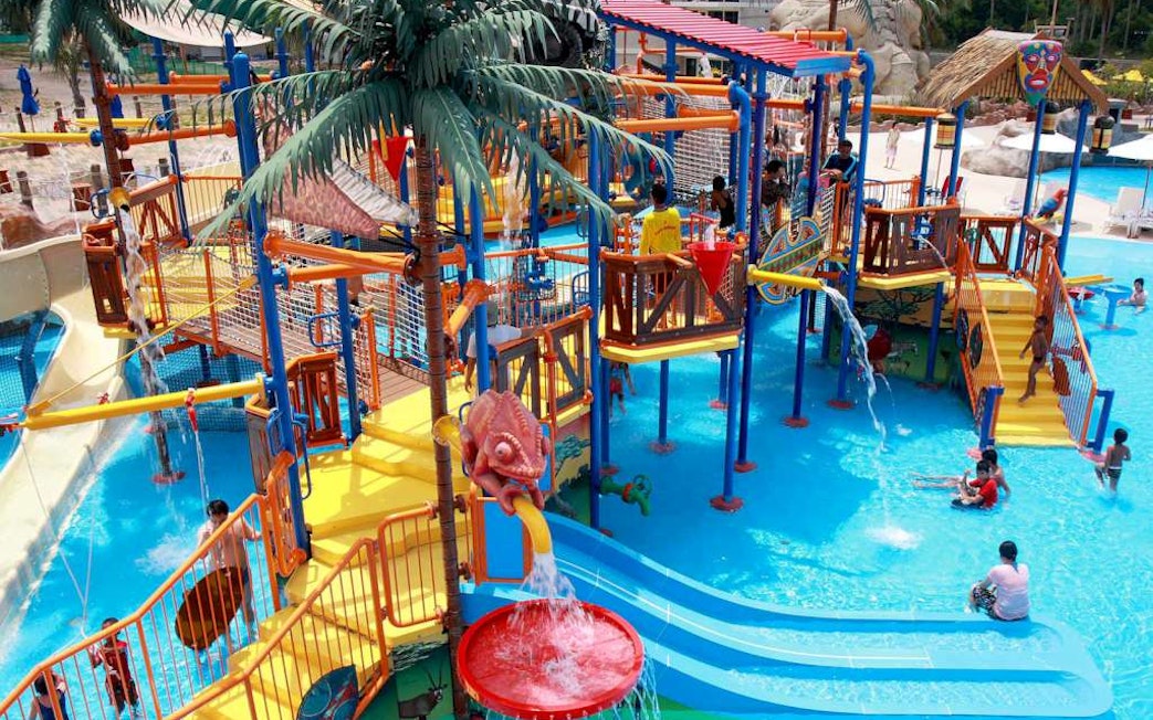 Children playing on colorful water slides and structures at Splash Jungle Waterpark.