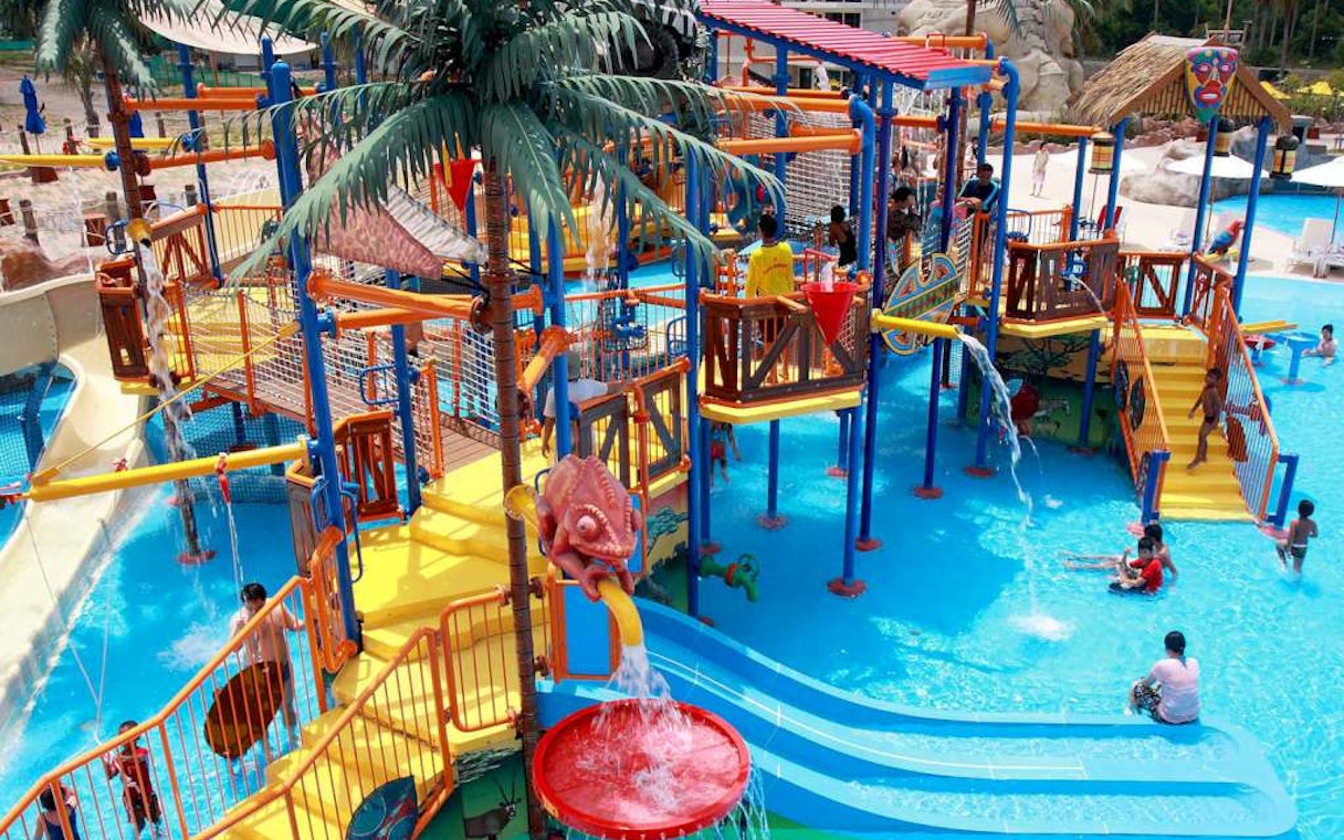 Children playing on colorful water slides and structures at Splash Jungle Waterpark.