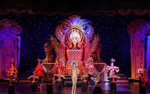 Performers in ornate costumes on stage at Aphrodite Cabaret Show.