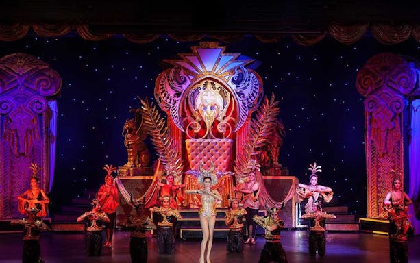 Performers in ornate costumes on stage at Aphrodite Cabaret Show.