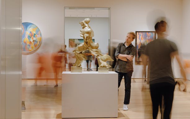 Museum visitor observing a modern sculpture at MoMA, New York City.