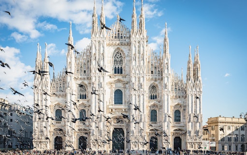 Duomo Milan Cathedral facade with birds flying, Italy.