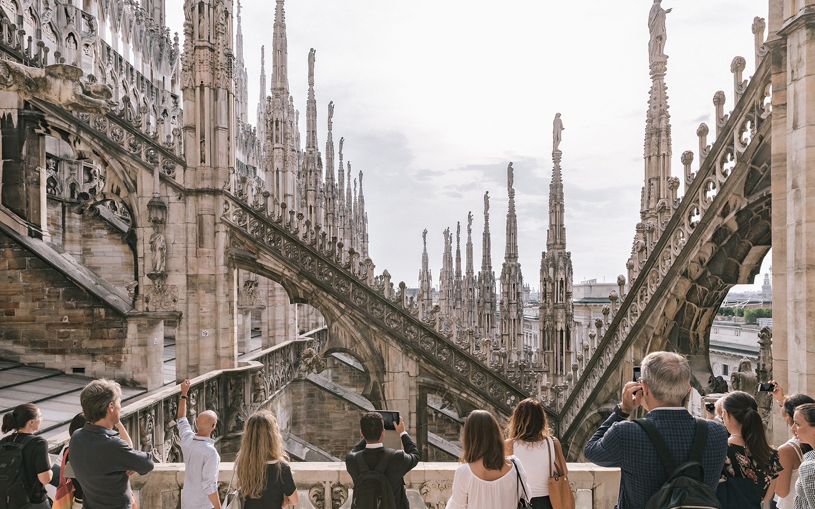 Tourists on Milan Duomo rooftop with spires in view, part of Combo: Milan Duomo + Leonardo's Vineyard tour.