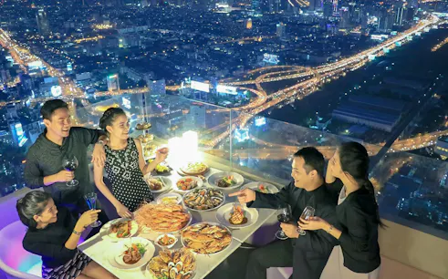 Dining experience at Baiyoke Floating Market Buffet, Baiyoke Sky Hotel's 75th floor, overlooking city lights.